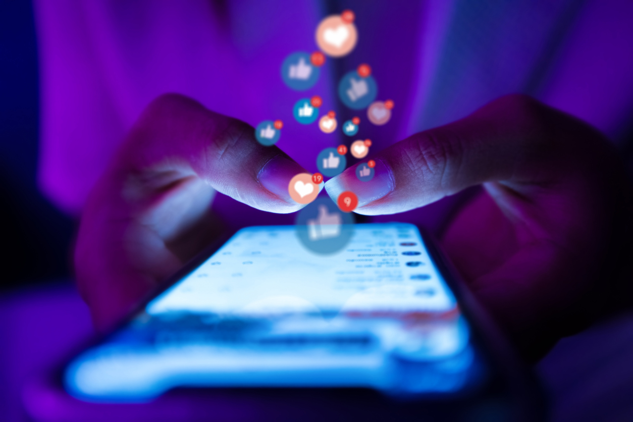 Person using smartphone for social media and showing engagement.
